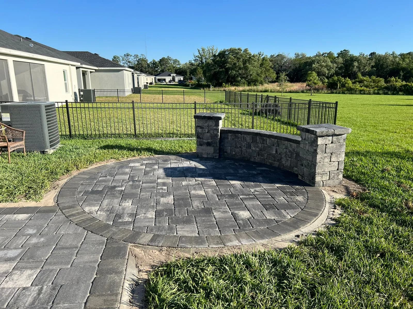 Circular paver patio with a curved sitting wall in Parrish, FL